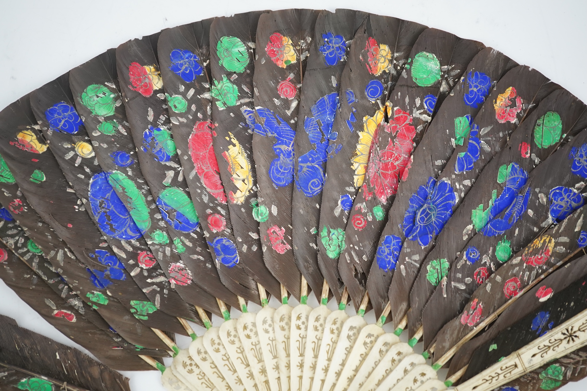 Three 19th century Chinese feather fans: One a carved bone brise black feather fan together with two similar carved sandalwood feather fans, two fans have hand painted decoration on the feathers both sides, the pink feat